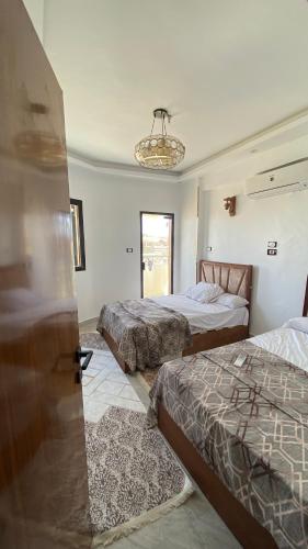 a bedroom with two beds and a chandelier at Super Elite apartment - Aswan city center apartments in Aswan