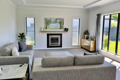 a living room with two couches and a fireplace at Sunny Delight in Clive in Clive