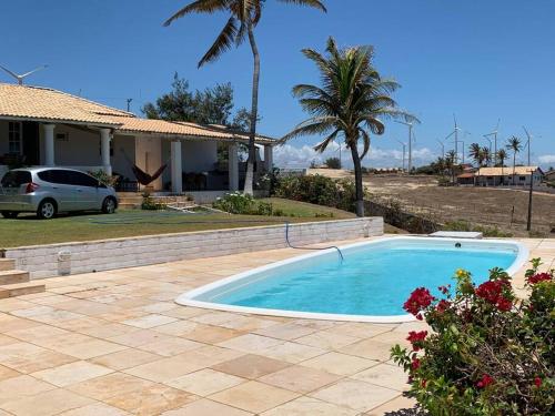 a swimming pool in a yard next to a house at Casa DuVentu Praia Fontes in Beberibe