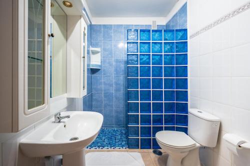a blue tiled bathroom with a toilet and a sink at Atlantic View Tenerife South in Arona