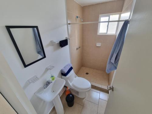 ein Badezimmer mit einer weißen Toilette und einem Waschbecken in der Unterkunft Hacienda de Cortés in Tlacote el Bajo