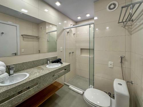 een badkamer met twee wastafels en een glazen douche bij Luxuoso Studio no Serra Class (307) in Canela