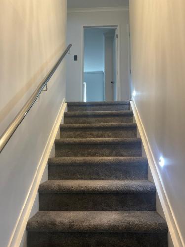 a stairway leading up to a room with a door at Holiday Home Papatoetoe 101 in Auckland