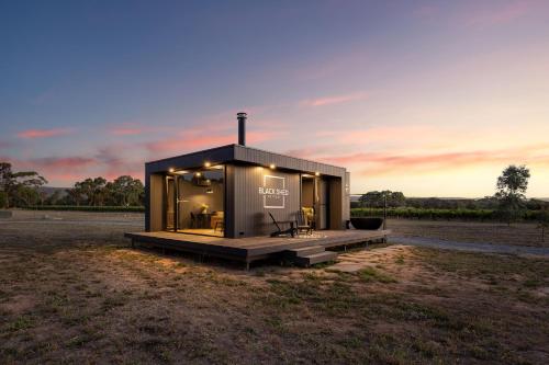 a tiny house in a field at sunset at Luxury Vineyard Cabin Escape in McLaren Flat