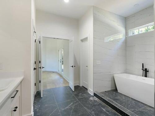 a white bathroom with a tub and a sink at Luxury Home 4B, 3B Sleeps 18 25min to Nashville in Greenlawn