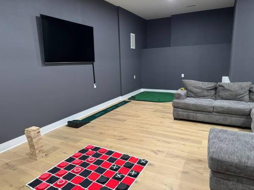 a living room with a couch and a flat screen tv at Luxury Home 4B, 3B Sleeps 18 25min to Nashville in Greenlawn