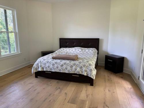 a bedroom with a bed and a wooden floor at Luxury Home 4B, 3B Sleeps 18 25min to Nashville in Greenlawn