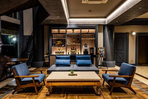 a living room with blue chairs and a table at Hotel Quest Shimizu in Shizuoka