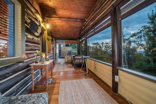 a screened in porch of a house with large windows at Romantic Retreat in the Dandenong Mountains in Kalorama