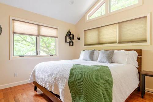 a bedroom with a large bed and two windows at Crows Nest Luxury Near Asheville in Marshall