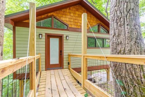 a tree house with a deck in the woods at Crows Nest Luxury Near Asheville in Marshall