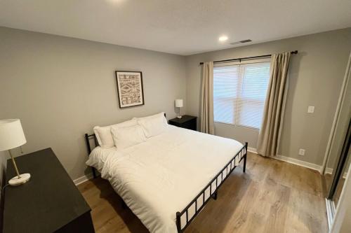 a bedroom with a bed and a table and a window at Aksarben Apt-Cozy One Bedroom in Omaha