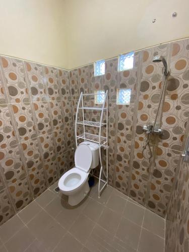 a bathroom with a toilet and a shower at Merapi View Homestay in Ngaglik