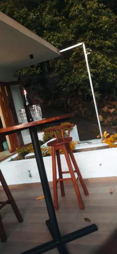 a picnic table with a chair and an umbrella at Kandy Lotus Chalet in Kandy