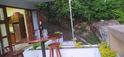 a table with a bottle of wine and two stools at Kandy Lotus Chalet in Kandy