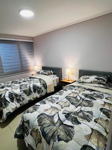 two beds sitting next to each other in a bedroom at Pewma House, by Pewma Apart Hotel in Chillán