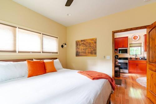 a bedroom with a large white bed and a kitchen at Poplar Treehouse - Rustic Luxury in Marshall