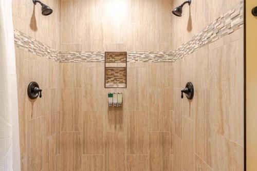 a shower with a wooden floor and a shower stall at Poplar Treehouse - Rustic Luxury in Marshall