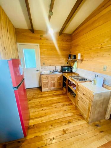 QueilénにあるCabañas Lugar de Refugioのウッドフロアのキッチン(白い冷蔵庫付)
