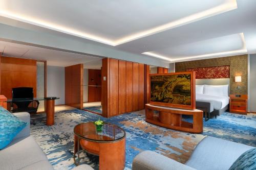 a hotel room with a bed and a living room at China Hotel Guangzhou - Subway direct to Pazhou Exhibition Center, Free shuttle during Canton Fair & Exhibitor registration Counter in Guangzhou