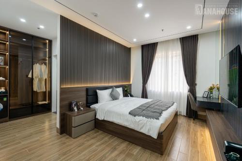 a bedroom with a bed and a dresser and a television at Khách sạn Trung Trầm in Dong Hoi