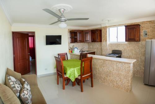 a kitchen with a table and chairs in a room at BNB Family Vacation Rentals, Corales del Sur, Santo Domingo Este in La Viva