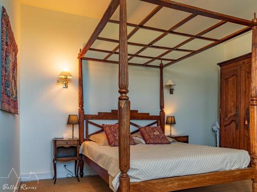drewnianym łóżkiem z baldachimem w sypialni z dwoma stołami w obiekcie Gîte de charme avec piscine chauffée et sauna, au cœur d'une propriété historique en Val de Loire - FR-1-381-128 w mieście Monnaie