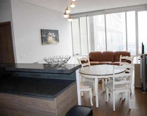 a kitchen and dining room with a table and chairs at Condo con Alberca a un Paso del Estadio Azteca in Díaz