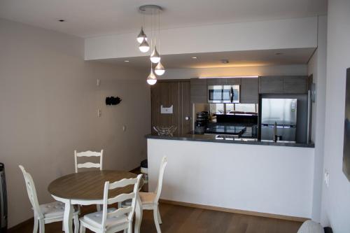 a kitchen and dining room with a table and chairs at Condo con Alberca a un Paso del Estadio Azteca in Díaz