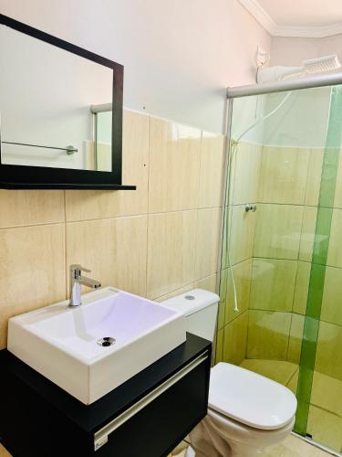 a bathroom with a sink and a shower at Apto 3 quartos, garagem, ar condicionado in Londrina