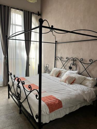 a bedroom with a black canopy bed with white sheets at Hotel Boutique Cantera in Querétaro