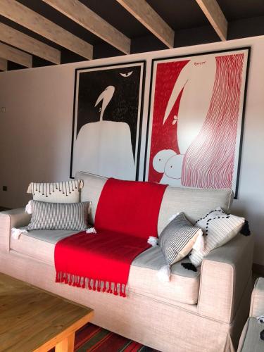 a couch in a living room with two pictures on the wall at CASA NEGRA SANTO DOMINGO in Santo Domingo