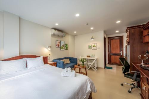a hotel room with a bed and a desk and chairs at Woody House Saigon Center in Ho Chi Minh City