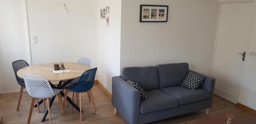 un salon avec un canapé bleu et une table dans l'établissement Cosy apartment close Eiffel Tower, à Sèvres