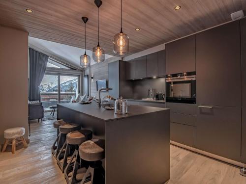 - une cuisine avec un grand îlot avec des tabourets dans l'établissement Location 5 pers. à Courchevel - 2 pas des pistes, centre station, spa, parking inclus, WiFi, parking - FR-1-631-199, à Courchevel