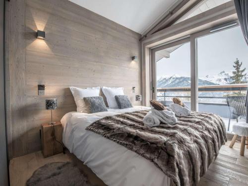 una camera da letto con un letto grande con una grande finestra di Location 5 pers. à Courchevel - 2 pas des pistes, centre station, spa, parking inclus, WiFi, parking - FR-1-631-199 a Courchevel
