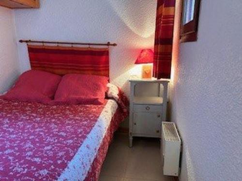 - une chambre avec un lit doté d'un couvre-lit rouge dans l'établissement Studio 4 pers à 100m des pistes, balcon sud, proche commerces - Risoul 1850 - FR-1-330-581, à Risoul