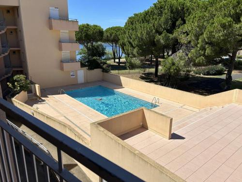 une piscine sur le côté d'un immeuble dans l'établissement Appt 2 pièces cabine climatisé avec piscine et parking à Port Camargue - FR-1-250-292, au Grau-du-Roi