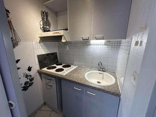une petite cuisine avec un évier et une cuisinière dans l'établissement Appt 2 pièces cabine climatisé avec piscine et parking à Port Camargue - FR-1-250-292, au Grau-du-Roi