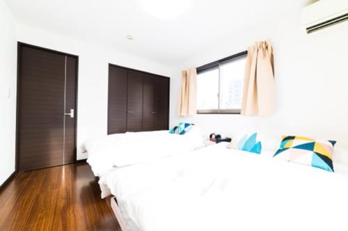 a bedroom with two beds and a window at Yahiro 4-chome House 2F,3F in Tokyo