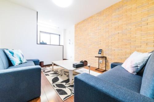 a living room with two blue couches and a table at Yahiro 4-chome House 2F,3F in Tokyo
