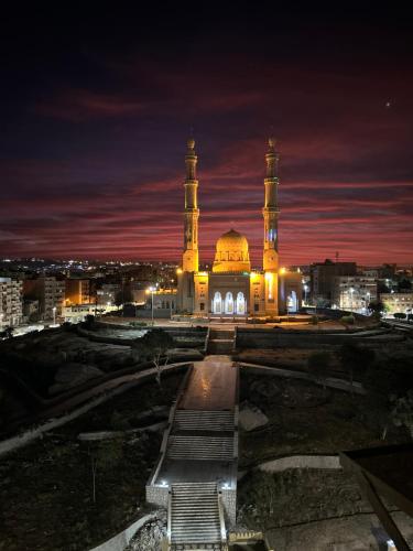 a large building with a mosque at night at Super Elite apartment - Aswan city center apartments in Aswan