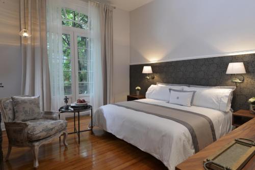 1 dormitorio con 1 cama grande y 1 silla en Casa Goliana La Roma en Ciudad de México