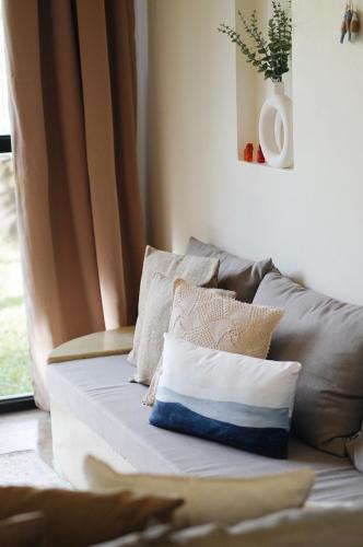 a couch with pillows on it in a living room at Villa Pura Vida Apartments Siargao in General Luna