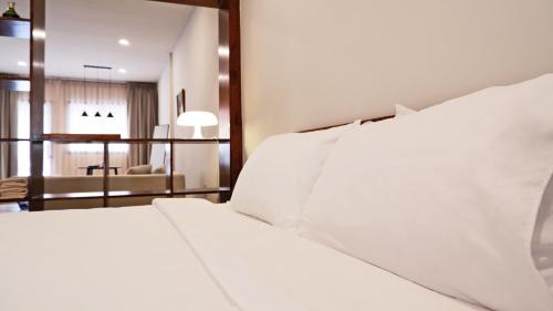 a bedroom with a white bed and a living room at The Studio in Loei