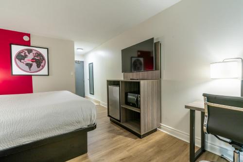 a hotel room with a bed and a desk at Ramada by Wyndham Kingston in Kingston