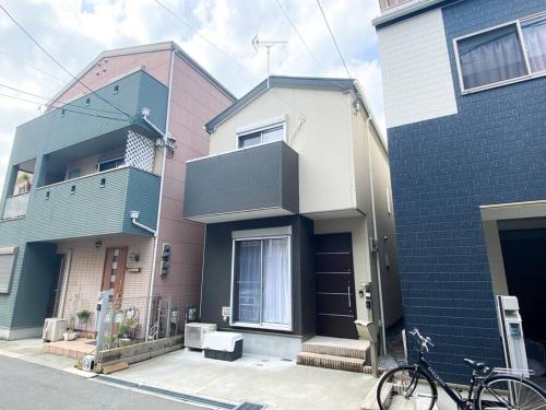 a bike parked in front of two buildings at Guest House 橘 関西空港直通,2階建て丸ごと貸切,難波,道頓堀まで2駅5分 in Osaka