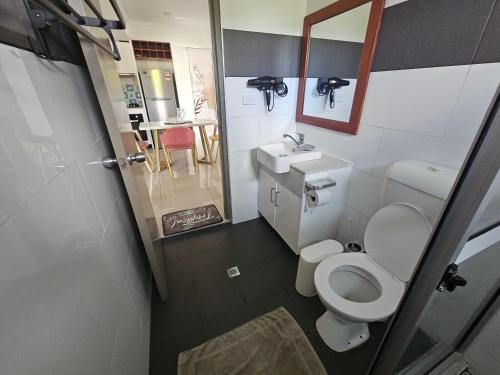 a small bathroom with a toilet and a sink at FIJI HOME Apartment Hotel in Suva