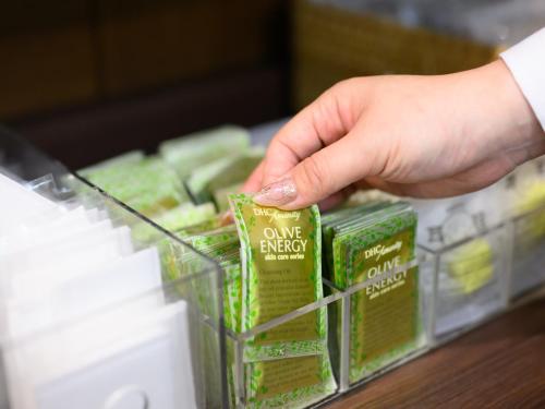 a person is selecting a packet of one agency products at Chisun Hotel Hiroshima in Hiroshima