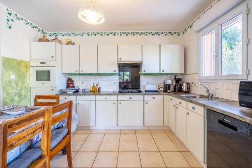 una cucina con mobili bianchi e un lavello di Villa Calanques a Ensuès-la-Redonne